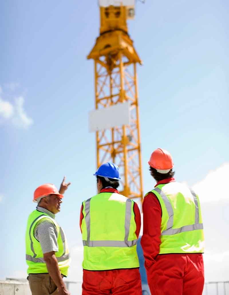 Professional construction management team inspecting project progress and scheduling tasks on NYC construction site