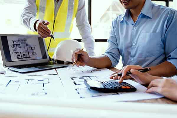 NYC construction company team reviewing blueprints and project plans in office