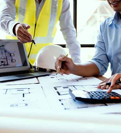 NYC construction company team reviewing blueprints and project plans in office