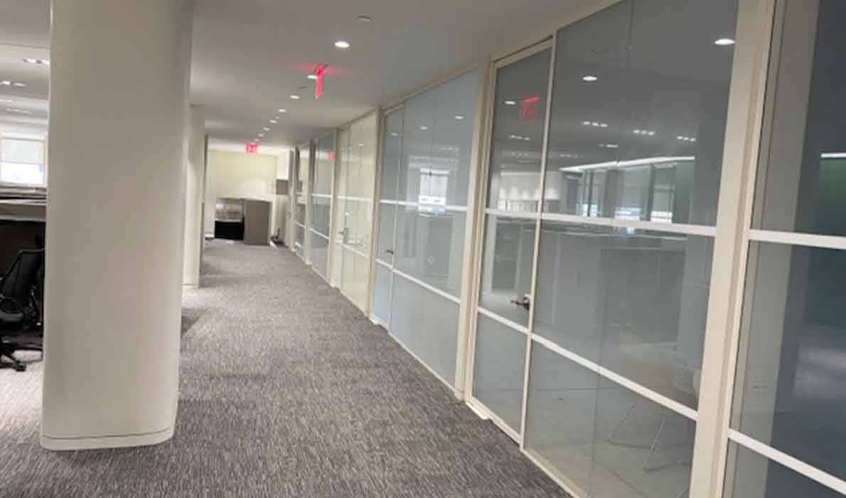 Office renovation in progress at 370 7th Avenue, NYC by Universal Contracting and Management, showing modern glass wall installations and architectural lighting design.